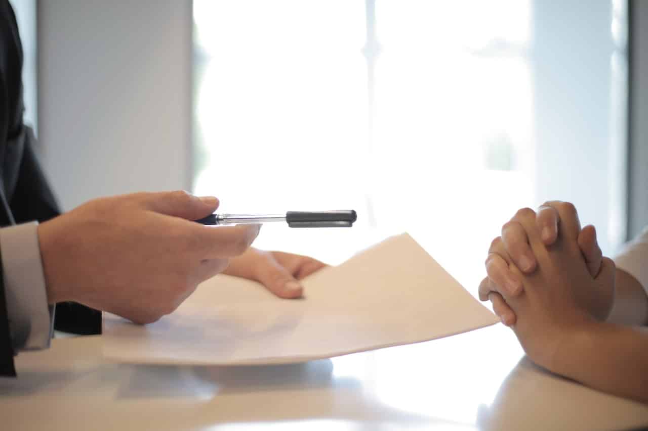 un jeune homme fait signer un contrat assurance entreprise à une femme
